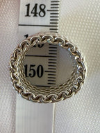 Top view of the silver mesh ring over a measuring tape, showing the inner opening.