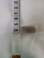 Side view of the silver mesh ring beside a measuring tape to show the width of the band.