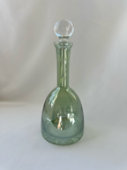 Alternate front view of green glass decanter showing rounded teardrop body and clear ball stopper.
