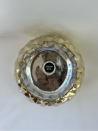 Bottom of Hazel & Co gold pineapple container showing maker label, decorative-use-only statement, and visible base wear.