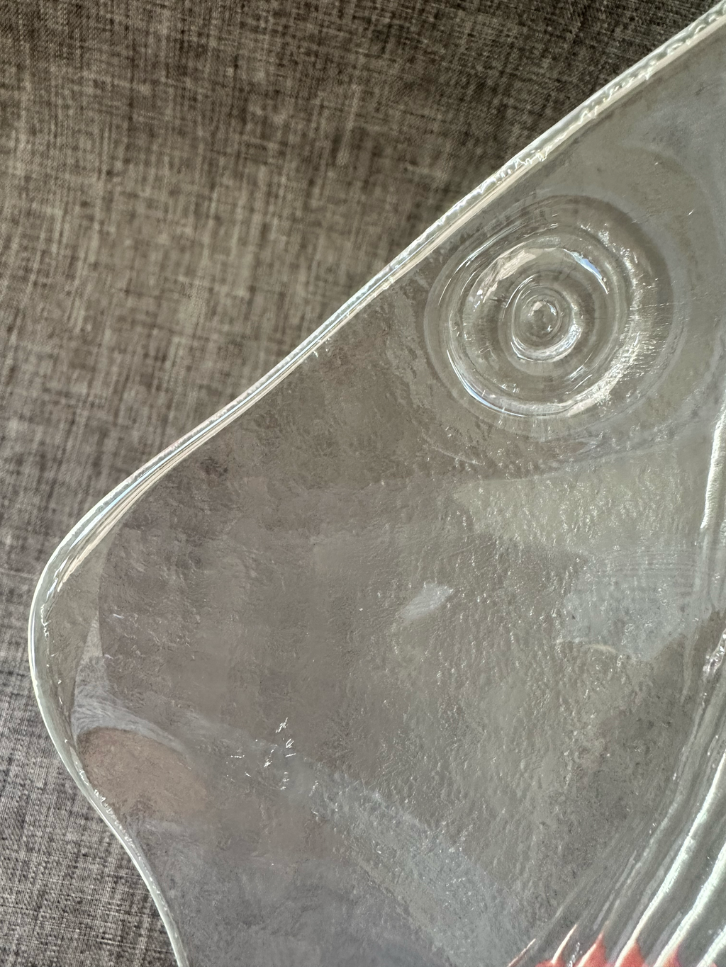 Detail of concentric bullseye eye on textured clear glass fish platter.
