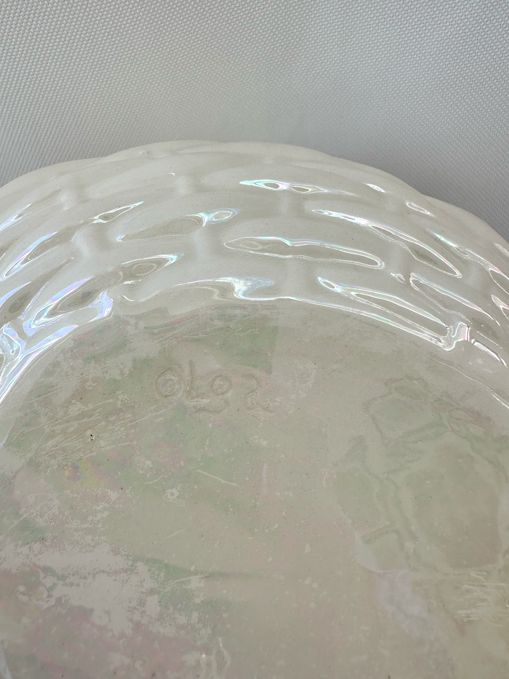 Close up showing maker's mark and small chip and scratches to the left of it