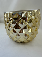 Side view of Hazel & Co gold ceramic pineapple container showing faceted geometric texture and reflective finish.

