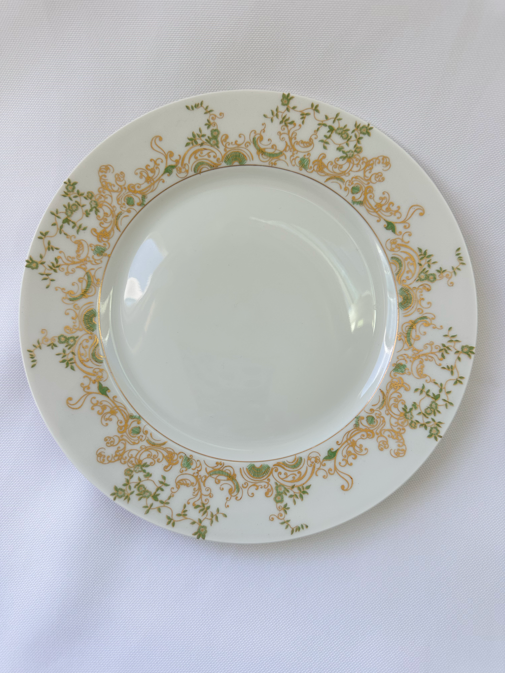 Haviland Limoges Chambord vintage salad plate with pale green center, green botanical border, and gold scroll decoration.
