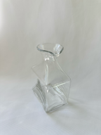 High angled view of clear glass vase showing the asymmetric opening and rolled glass rim.
