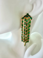 Kate Spade emerald green fringe statement earring shown on mannequin ear for scale.
