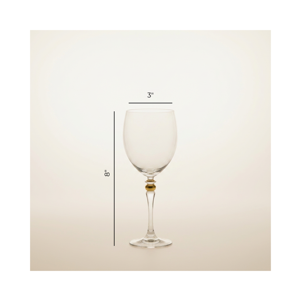 A clear wine glass with a small gold accent at the base of the stem, shown on a light beige background with dimension lines indicating 3 inches wide at the bowl and 8 inches tall.