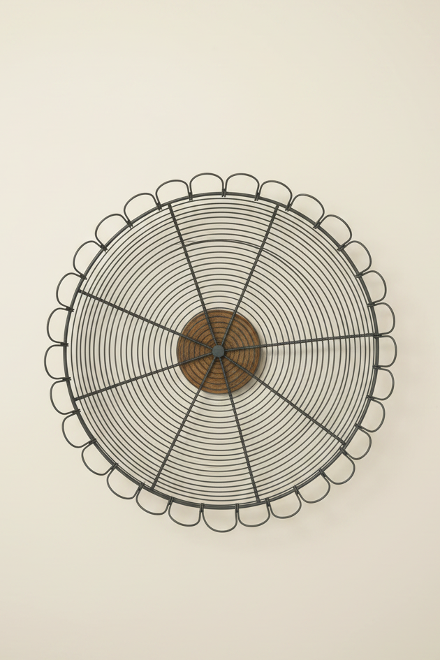 Overhead view of round dark wire pedestal bowl with looped scalloped edge and wood center.
