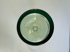 Overhead view into green glass decanter showing circular base and visible interior discoloration.
