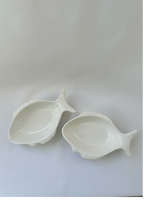 Set of two matching glossy white ceramic fish-shaped bowls with raised molded fish details.