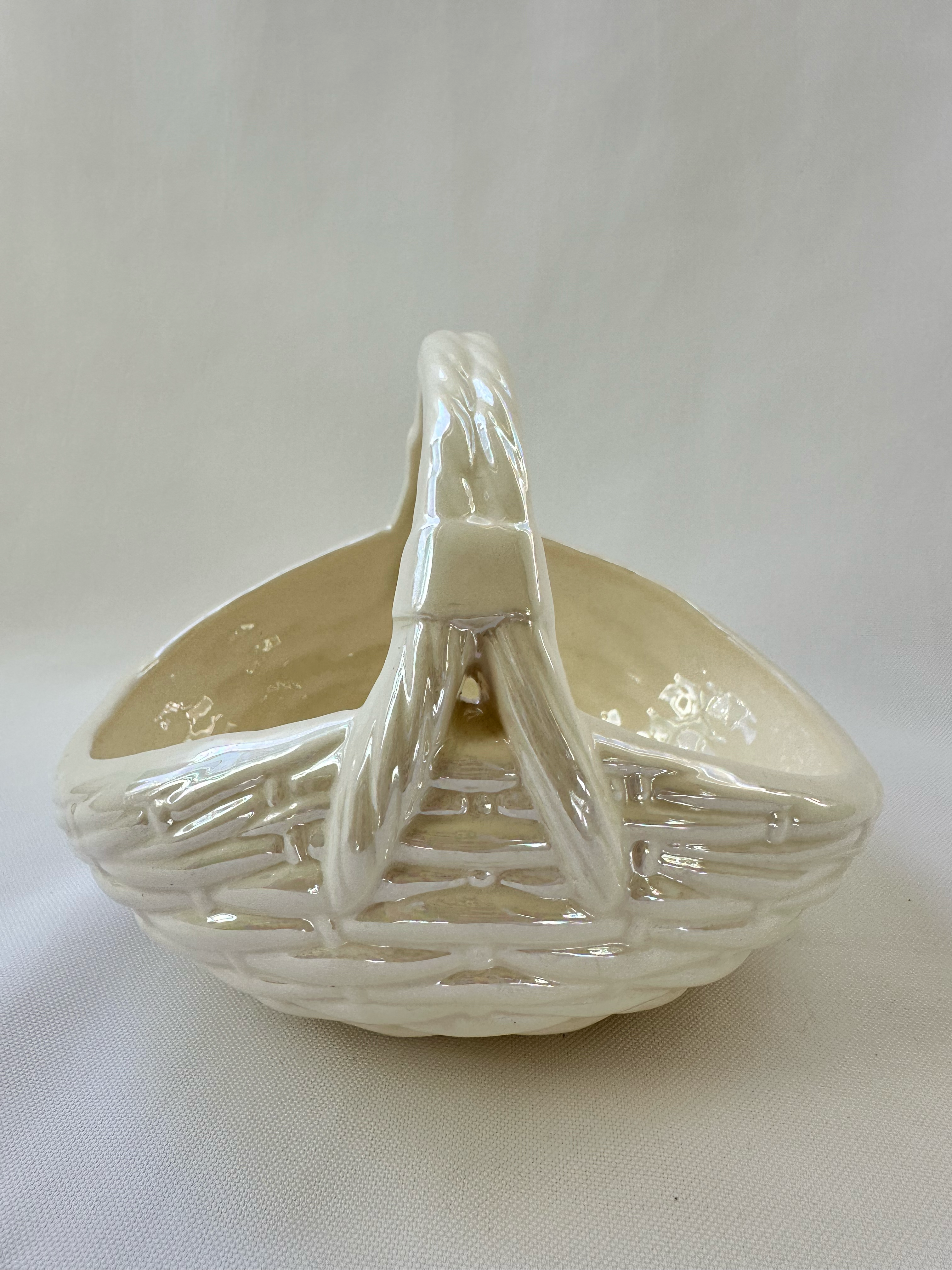 Side view of white ceramic basket bowl.
