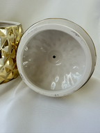 Open Hazel & Co gold pineapple decorative container with removable lid showing white glazed interior of lid, along with slight wear. 
