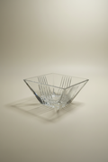 The Tiffany & Co. Metropolis clear crystal bowl with a faceted geometric top and ribbed base, shown in a studio setting with an ivory background.  