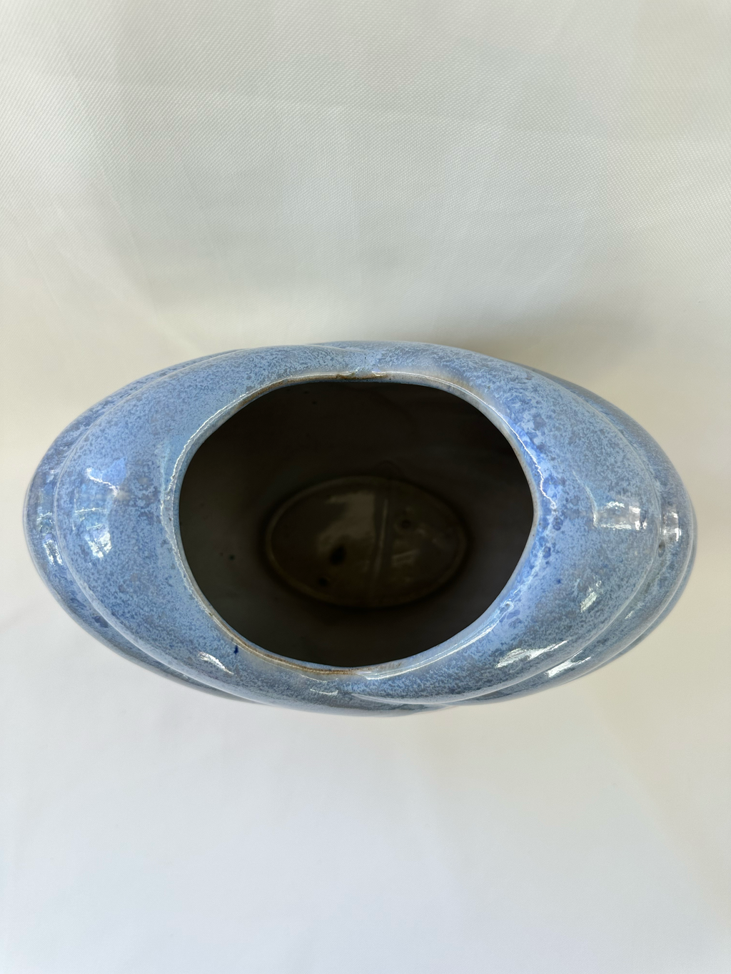Overhead view of ceramic vase showing the heart-shaped opening and mottled pale-blue glaze.
