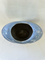 Overhead view of ceramic vase showing the heart-shaped opening and mottled pale-blue glaze.
